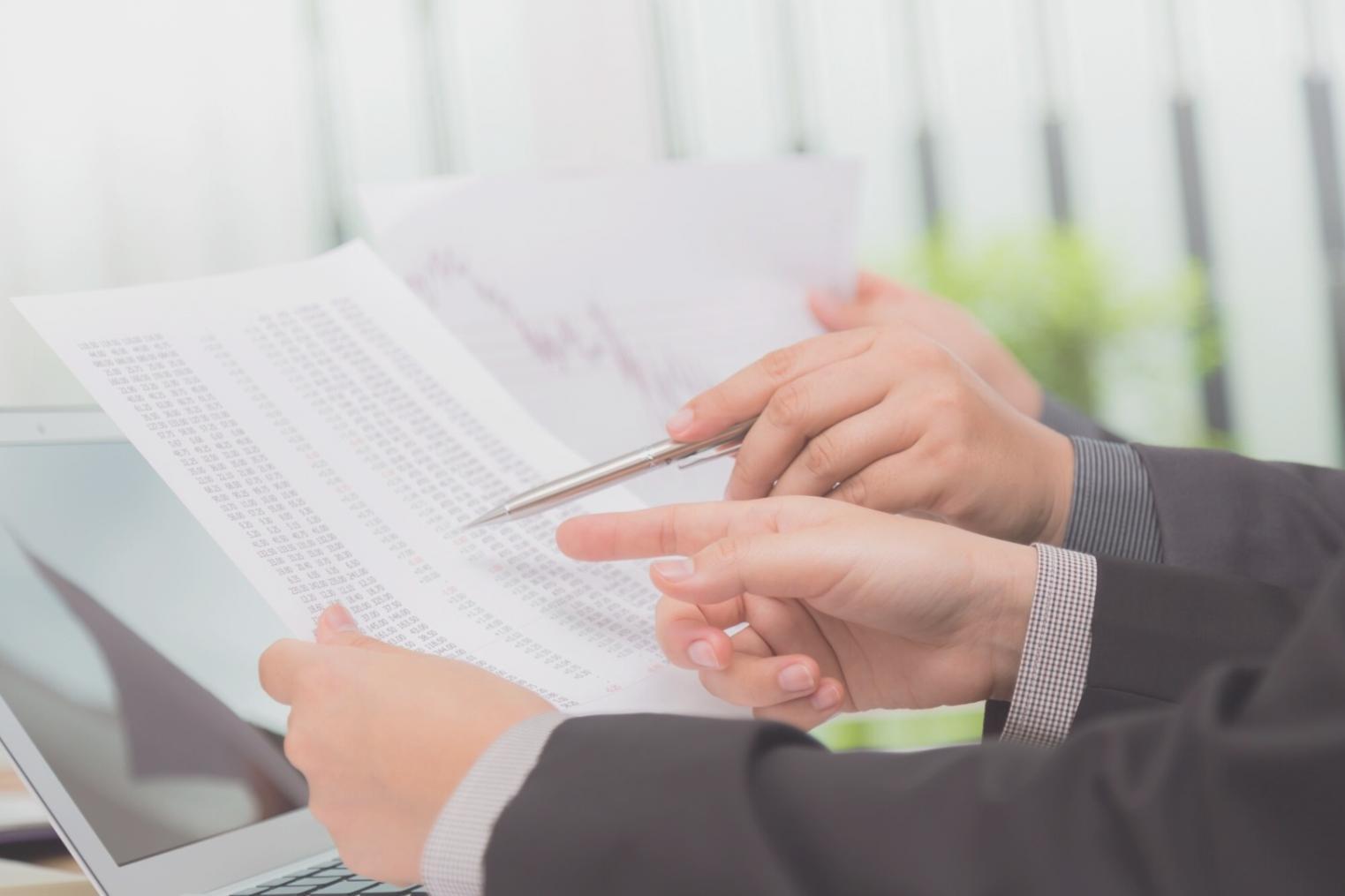 Frau arbeitet konzentriert am Computer mit Finanzdiagrammen